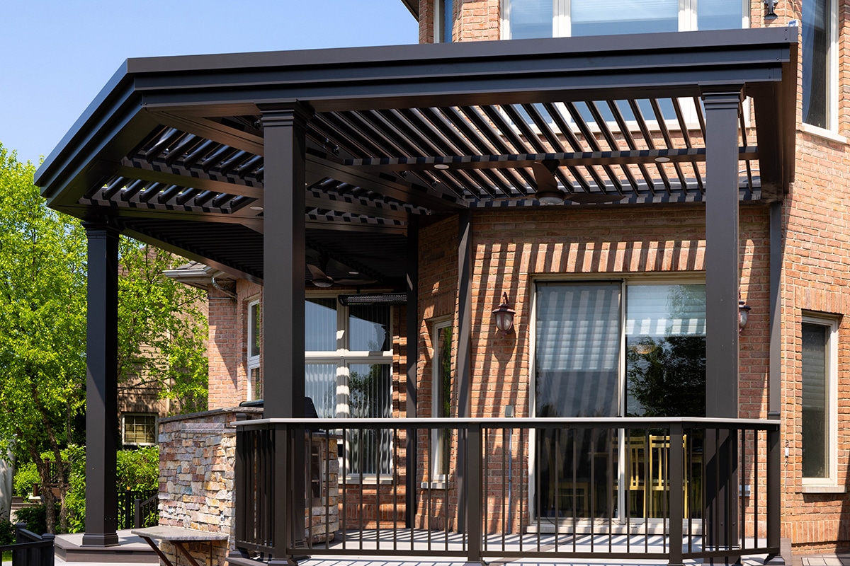 The Smart Pergola louvered pergola installed over a residential deck attached to a brick home.