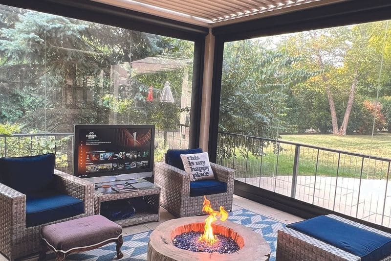 screened attached residential pergola featuring tv and fireplace