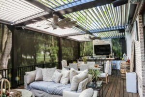 An outdoor entertainment space protected from the elements by a retractable louvered pergola from The Smart Pergola®.